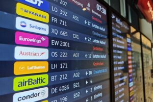Lufthansaflieger am Flughafen, Passagiere betroffen von anstehenden Streiks, Unruhe und Stornierungen sichtbar.