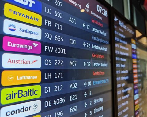 Lufthansaflieger am Flughafen, Passagiere betroffen von anstehenden Streiks, Unruhe und Stornierungen sichtbar.