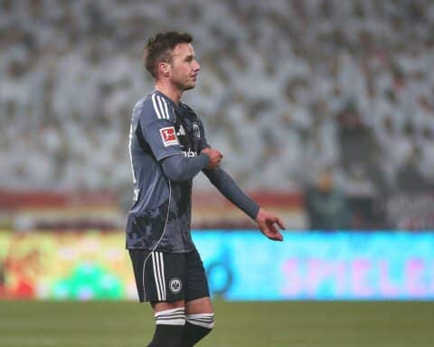 Mario Götze in Aktion mit Eintracht Frankfurt-Logo, Vertragverlängerung und Teamgeist symbolisierend.