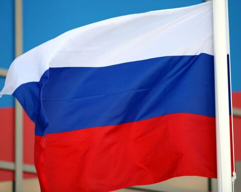 Fahne Russlands vor gerichtlichem Hintergrund, symbolisiert Repression gegen Menschenrechte und Erinnerungsarbeit.