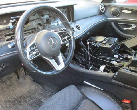 Aufgebrochener Mercedes vor Haus, beschädigte Fenster, Polizei ermittelt, Täter stehlen wertvolle Teile.