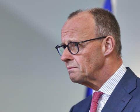 Friedrich Merz in Uniform, bei militärischer Vorführung, betont Bundeswehrinvestitionen und internationale Zusammenarbeit.