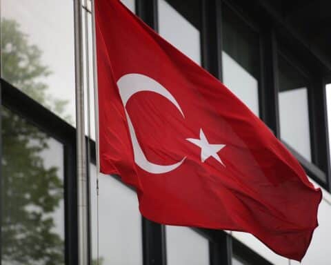 Türkische Fahne vor einer Schule, symbolisierend die Tragödie eines Amoklaufs und Verlust.