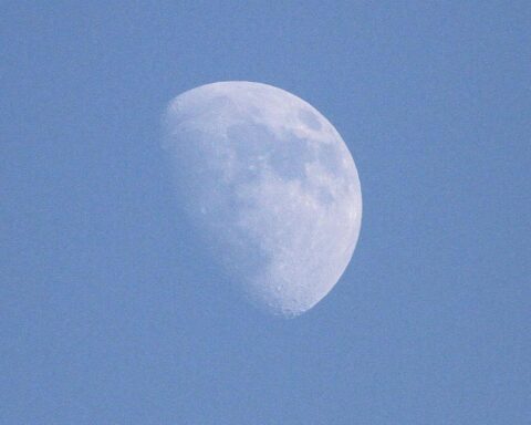 Astronauten der Artemis-2-Mission brechen Rekord, Mond und blauer Himmel im Hintergrund.
