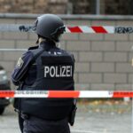 Polizistin hinter Absperrband am Unfallort eines tödlichen Motorradunfalls auf Bundesstraße 208.