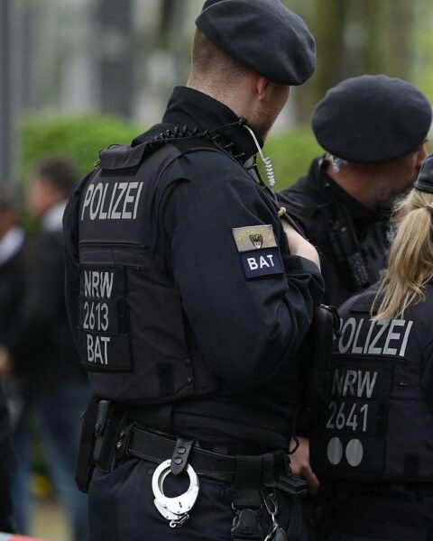 Polizisten sichern Unfallstelle, Motorrad liegt beschädigt auf Landesstraße nach tödlichem Sturz.