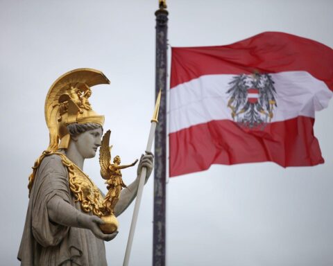 Österreichische Fahne vor dem Hintergrund von Wirtschaftspolitik und Energiefragen in Europa.