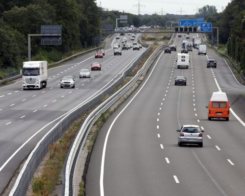 Autobahn mit Fahrzeugen und Verkehrszeichen, symbolisierend die Diskussion um hohe Pendlerpauschalen.