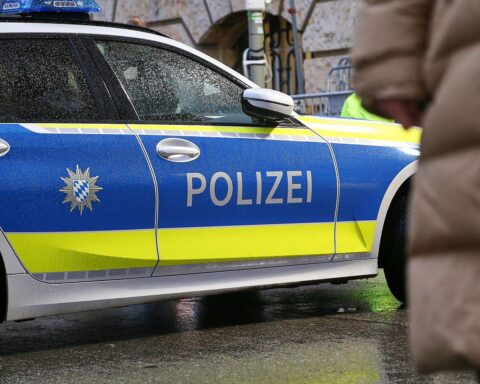 Polizeiauto vor urbanem Hintergrund, Symbol für Ermittlungen zu mehreren Straftaten in Würzburg.