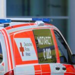 Ein schwer verletzter Rennradfahrer wird von einem Rettungswagen versorgt, Polizei ermittelt.