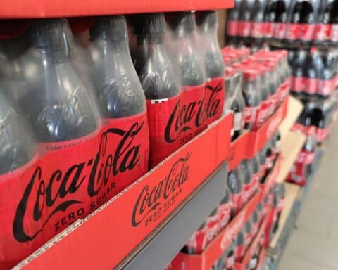 Coca-Cola-Getränke im Supermarkt, symbolisieren Diskussion um Zuckersteuern und Gesundheitspolitik.