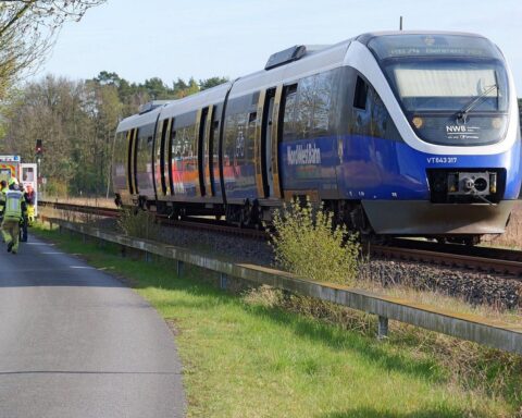 Einsatzkräfte der Feuerwehr helfen nach Reizgasvorfall in Zug, Türen offen, besorgte Passagiere.