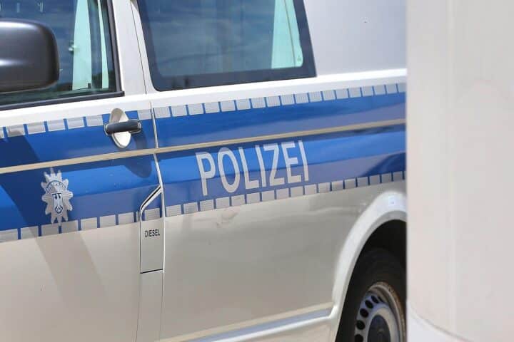 Polizeiauto am Einsatzort, Einsatzkräfte, Schüler evakuiert, Rettungsdienst vor Ort, Sicherheitsmaßnahmen.