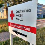 Ein Bild des DRK-Logistikzentrums, symbolisiert durch Rettungsgeräte und ehrenamtliche Helfer.