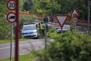 Verkehrskontrolle an der deutschen Grenze, Beamte im Einsatz, potenzielle Sicherheitsmaßnahmen sichtbar.