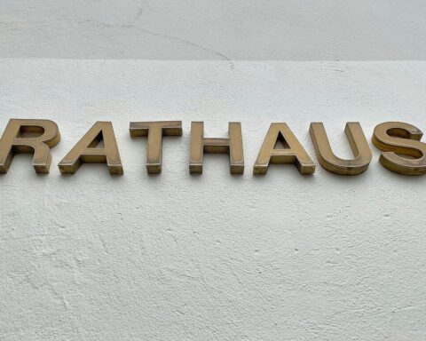 Dresdner Rathaus mit Symbolen für Bürokratieabbau und digitale Verwaltung, repräsentiert Reformideen.