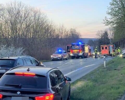 Trümmerfeld nach schwerem Verkehrsunfall: beschädigte Fahrzeuge und Rettungsmaßnahmen sichtbar.