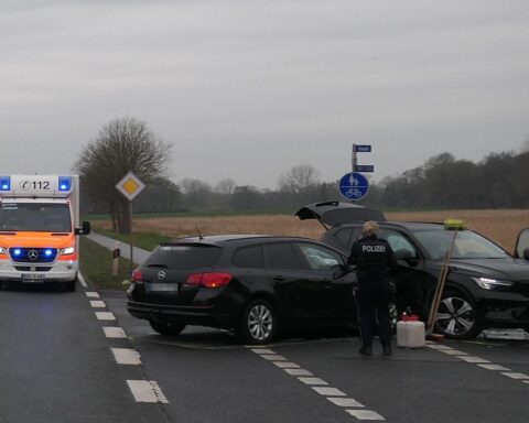Zwei beschädigte Autos an einer Bundesstraße, Einsatzwagen der Polizei und Rettungshubschrauber sichtbar.