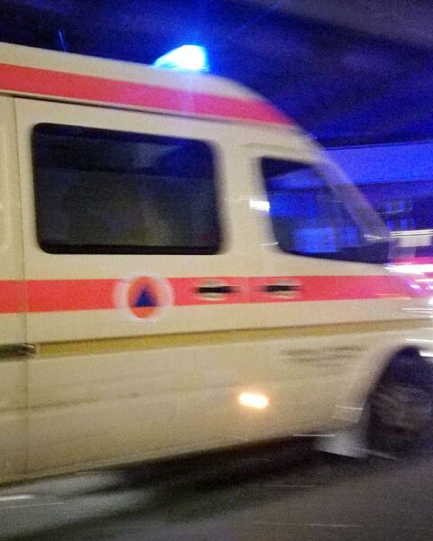 Krankenwagen am Unfallort eines schweren Verkehrsunfalls mit einem umgestürzten Fahrzeug.