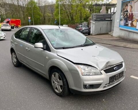 Verunfallter Pkw an der Straße, Radfahrerin verletzt, Polizei vor Ort, Einsatzfahrzeuge sichtbar.