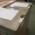 Wahllokal in Schwerin mit Wahlurnen und Wählern, die zur Stichwahl am Oberbürgermeister abstimmen.