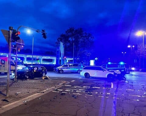 Zwei beschädigte Autos an einer Kreuzung, Polizei und Rettungsdienste im Einsatz.