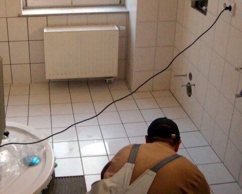 Fliesenleger bei der Arbeit, Symbol für Handwerkerleistungen und den diskutierten Steuerbonus.