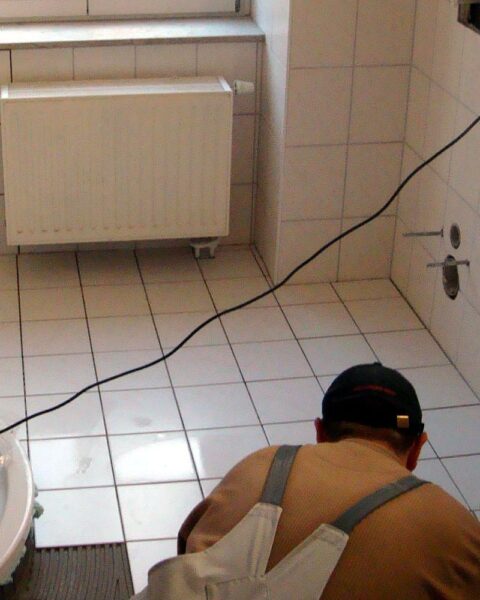 Fliesenleger bei der Arbeit, Symbol für Handwerkerleistungen und den diskutierten Steuerbonus.