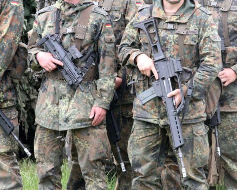 Bundeswehr-Soldaten mit Rüstungsgütern, symbolisieren Deutschlands Waffenimportabhängigkeit bis 2035.