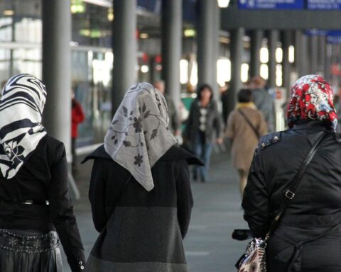 Mehrere Frauen mit Kopftüchern auf einer belebten Straße, symbolisierend kulturelle Diversität in Europa.