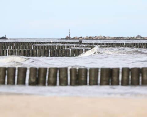 Küstengebiet mit sinkendem Grundwasserspiegel, Symbol für Versalzung und Trinkwassergefährdung.