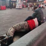 Obdachlose am Times Square reflektieren soziale Herausforderungen trotz sinkender Arbeitslosenzahlen in den USA.