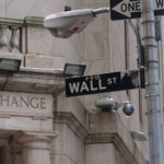 Blick auf die Wall Street mit Finanzdaten und steigenden Öl- sowie fallenden Goldpreisen.