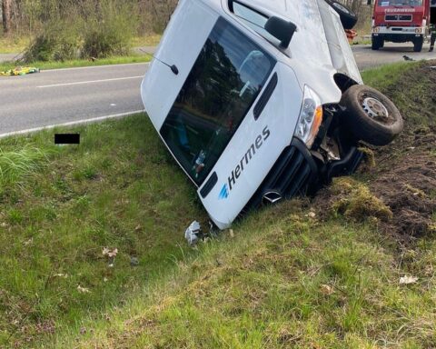 Ein beschädigter Pkw im Graben, Unfallstelle mit Polizei und Absperrung, verletzte Personen.