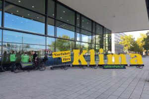 Protestierende für Klimaschutz, Transparente, grüne Farben, Hoffnung auf erneuerbare Energien, internationale Zusammenarbeit.