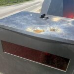 Beschädigter Blitzeranhänger mit Dellen, umgeben von Polizeiabsperrungen in Dreilützow.