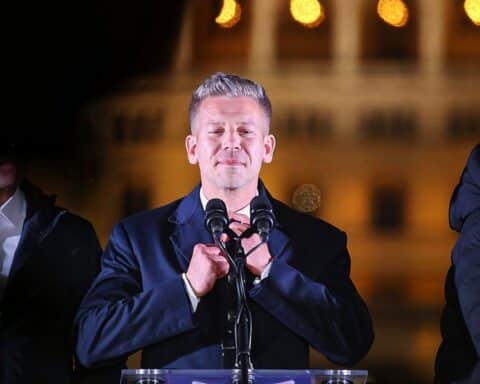 Péter Magyar feiert Wahlsieg, umgeben von jubelnden Anhängern und festlicher Stimmung am Donauufer.