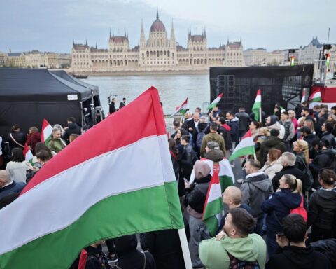 Feiernde Menschen unterstützen Tisza-Partei bei Wahlparty, Jubel über Wahlerfolg und Veränderungen.