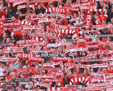 Marie-Louise Eta, erste Trainerin in der Bundesliga, umgeben von leidenschaftlichen Union Berlin-Fans.