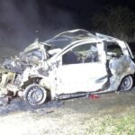 Brennender Renault Twingo auf einem Feldweg, Feuerwehr im Einsatz, Nachtaufnahme.