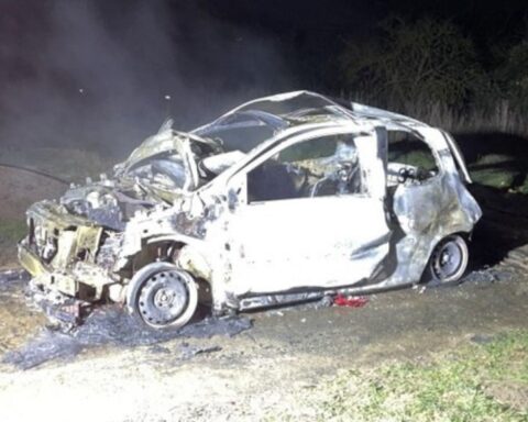 Brennender Renault Twingo auf einem Feldweg, Feuerwehr im Einsatz, Nachtaufnahme.