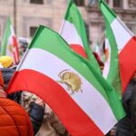 Demonstration gegen Iran, Protestbanner, Menschenmenge, Menschenrechtsanliegen, politische Spannungen, friedlicher Protest.