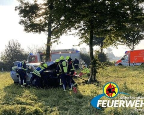 Zwei beschädigte Autos nach Zusammenstoß auf der Odenkirchener Straße; Feuerwehr und Rettungsdienst im Einsatz.