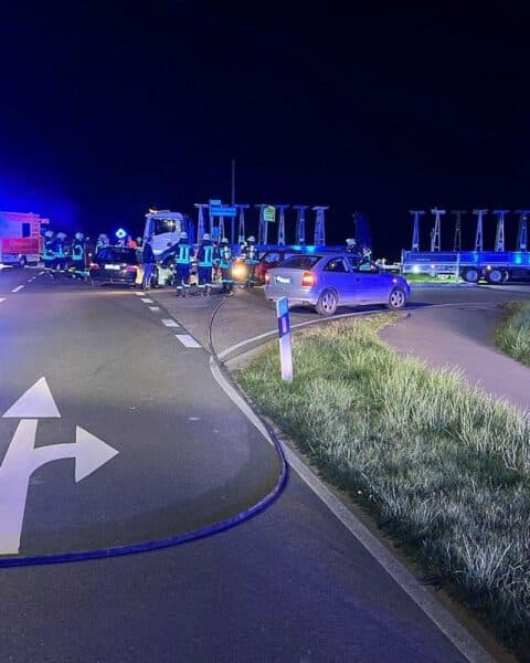 Verkehrsunfall mit mehreren Verletzten auf belebter Straße, Rettungswagen und Polizeipräsenz sichtbar.