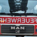 Feuerwehr im Einsatz bei Brand in Mehrfamilienhaus mit verletzten Personen.