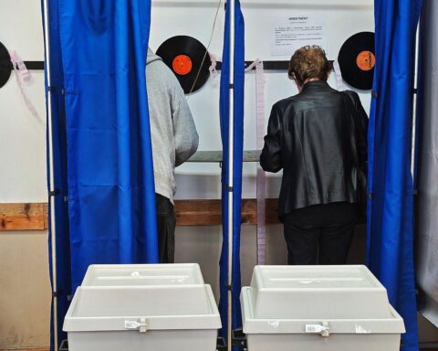 Wahllokal in Ungarn: Wähler vor geschlossenen Türen, hohe Wahlbeteiligung, politische Spannung.