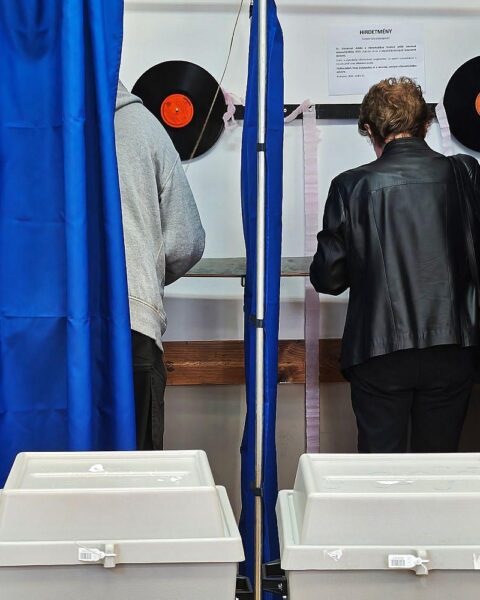 Wahllokal in Ungarn: Wähler vor geschlossenen Türen, hohe Wahlbeteiligung, politische Spannung.