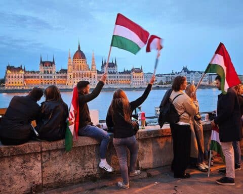 Tisza-Anhänger feiern Wahlsieg, symbolisieren proeuropäische Bewegung gegen Rechtspopulismus in Ungarn.