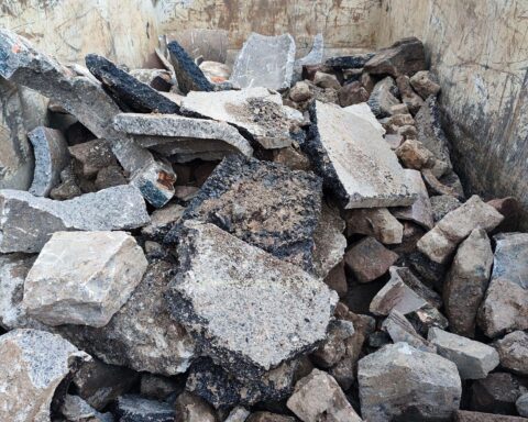Bauschutt und Recyclingmaterialien in einer Aufbereitungsanlage, symbolisieren Abfallreduzierung und Nachhaltigkeit.