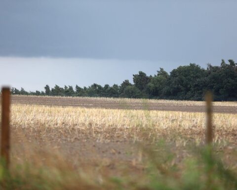 Frostige Landschaft mit leichtem Schnee, Wolken und Sonnenstrahlen über Baden-Württemberg.